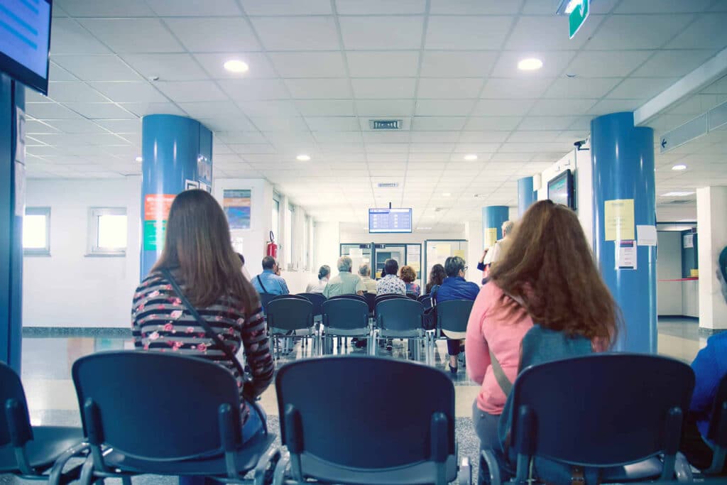 people in a waiting room of hospital, men and women wait their t