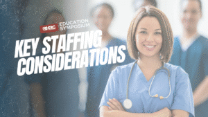 Smiling healthcare professional in scrubs with a stethoscope, standing with arms crossed. Blurred medical staff in the background. Text reads 'RHRC Education Symposium' and 'Key Staffing Considerations.